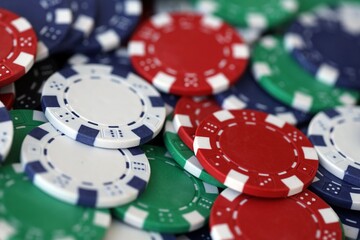 Close up of a group of casino chips on a green mat for poker or dice games indoors