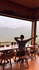 Handsome Man Relaxing in Cafe with Beautiful Morning Misty Valley View