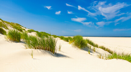 Panorama in the sand dunes of the East Frisian North Sea island of Wangerooge with a view of the beach and the sea horizon. Wadden Sea National Park, nature reserve, and popular tourist destination.