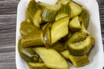 slices of pickled cucumber, pickle, gherkin, cucumber that has been pickled in a brine, vinegar, or other solution and left to ferment, part of mixed pickles, food appetizer