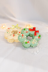 macaron dessert in shape of christmas wreath. homemade unique cookie. bow and sprinkles. white and green. isolated