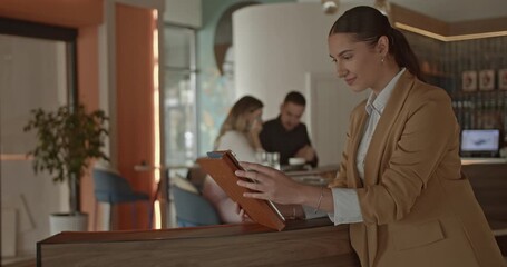 Confident female business owner efficiently manages operations on a digital tablet in her thriving small business. This scene highlights modern entrepreneurship and the growth of a contemporary cafe. - Powered by Adobe