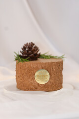 christmas brown cake decorated. with branches and cone. chocolate tasty treat for celebration. white background
