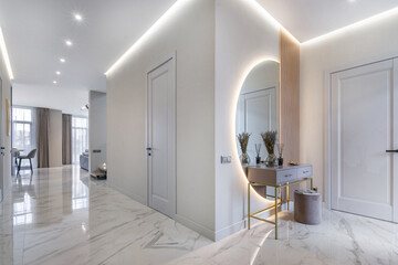 Elegant entrance hall with marble floors, stylish decor and soft lighting in a modern house.