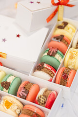 macaron dessert for christmas. homemade unique cookie. bow and sprinkles. various colors. present box. white