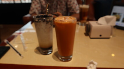 drinks on a table with a cafe in the background.