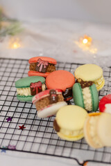 macaron dessert for christmas. homemade unique cookie. bow and sprinkles. various colors. present box. white