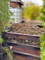 Compost with leaves in the garden in autumn vertical
