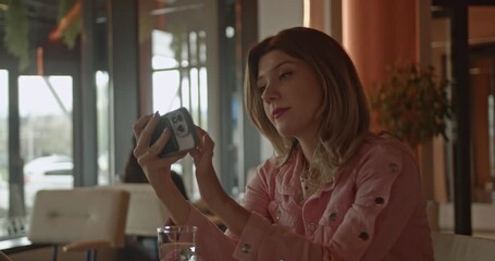 A confident businesswoman engages in a virtual video call from a modern cafe, showcasing remote communication and technology integration. - Powered by Adobe