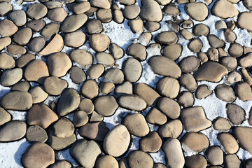 Rounded natural stones arranged on snow