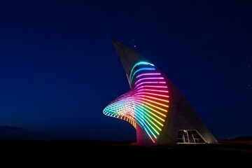 Illuminated sculpture under a dark sky with vibrant colors and unique architecture