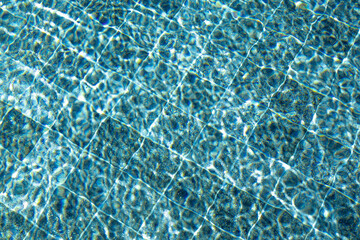 pool water abstract background with mosaic pattern. close up view of crystal clear turquoise water with ripples and wavy patterns