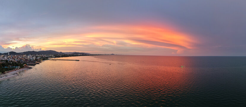 vivid sunset scenery, enchanting shoreline bathed in pink reflections with sweeping cinematic cloud Hua Hin Thailand