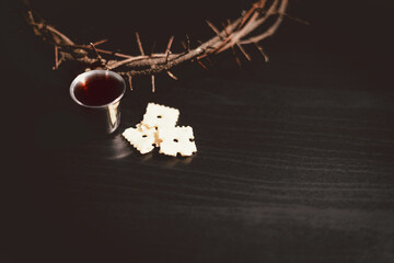 Communion bread and wine with the Holy Bible and crown of thorns, symbolizing the sacrifice of...