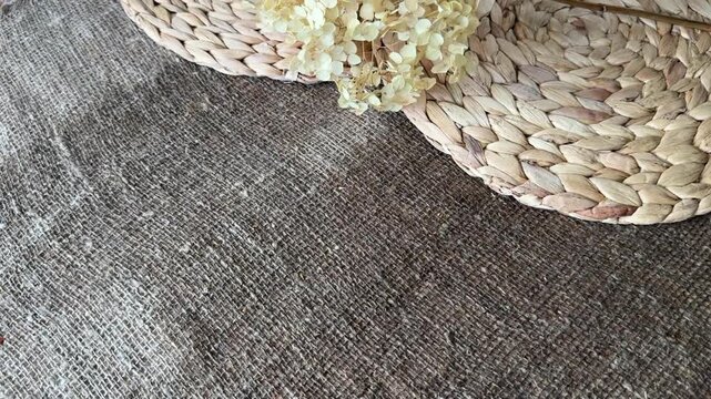 Lush dried hydrangea flower on damp linen burlap and water hyacinth placemats, Autumn background