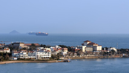 Fototapeta premium Overlooking Qingdao Coastal Old Town from Xiaoyu Mountain, German Architectural Landscape with Red Tiles and Blue Sea