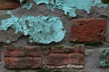 Background of a crumbling wall made of red clay brick and turquoise painted cement plaster