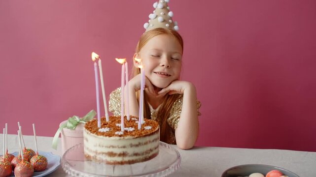 baby girl make a wish on birthday cake
