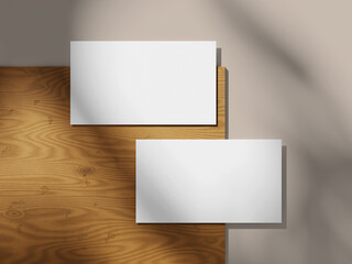 Simple business card mockup on a wood background with a smooth shadow effect.