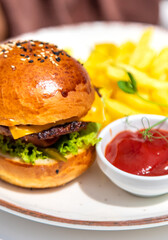Burger, fries and ketchup on a plate. Selective focus.