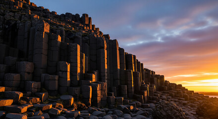 Fire and Stone: Basalt Columns Ablaze in Sunset Light
A dramatic, low-angle landscape capturing a wall of towering hexagonal basalt columns sharply lit by the vivid, warm light of a sunrise or sunset