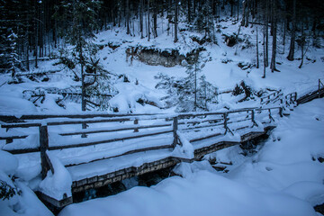 winter path over a bridge on a mountain trail