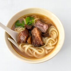 A bowl of hearty noodle soup with tender meat chunks and fresh green herbs noodles