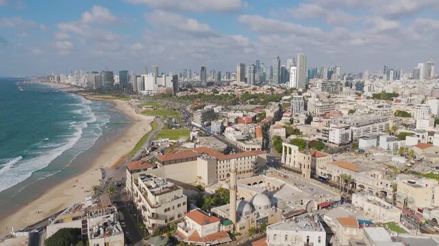 Aerial view of the rustic architecture of Old Jaffa meeting the modern skyline along the coast, showcasing a blend of history and progress, Tel Aviv-Yafo, Israel.