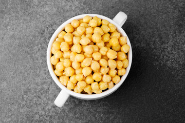 Chickpeas in white bowl on dark background for vegan protein, legume food or healthy eating concept