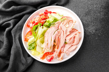 White bowl salad with cherry tomatoes, cheese, pepper and turkey for protein meal, diet food or fitness lifestyle concept