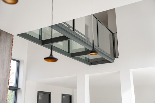 Pont en verre moderne &agrave; l&rsquo;int&eacute;rieur d&rsquo;une maison, reliant deux espaces et offrant une structure design transparente qui met en valeur la lumi&egrave;re et l&rsquo;architecture contemporaine.