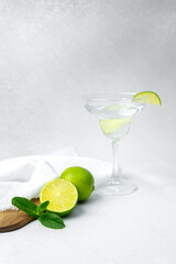 Refreshing lime cocktail garnished with mint on a wooden surface