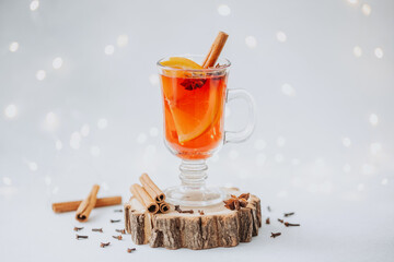 Warm winter mulled wine with orange slices, cinnamon, and star anise on rustic wood