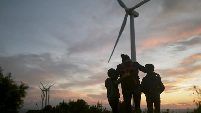 Family watching wind power generators in a rural landscape, representing environmental concerns, clean energy, and the hope for a greener planet and future generations