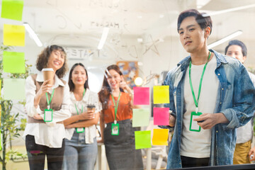 Confident creative agency teamwork asian male and female standing together smile portrait shot they area working in modern studio workshop office