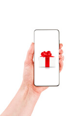 Female hand holds smartphone with white gift box with red ribbon on screen isolated on white background with clipping path. Design element. Winter or Christmas sales and discounts.