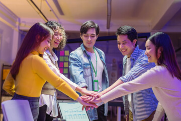 confident business team joins hands together in a late-night office meeting, celebrating success, unity, and empowerment. The scene reflects teamwork, motivation, and the collaborative spirit 