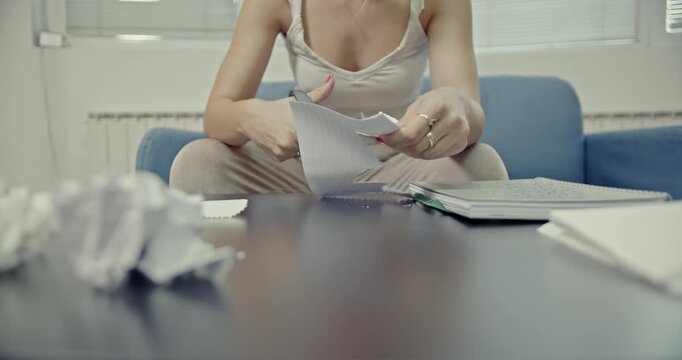 A close-up view of a woman's hands cutting paper with zig-zag scissors and then crumbling it, featuring crisp, satisfying sounds perfect for creative projects or ASMR content.