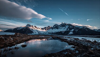 Snow-capped Mountains Reflecting in Water Under a Blue Sky