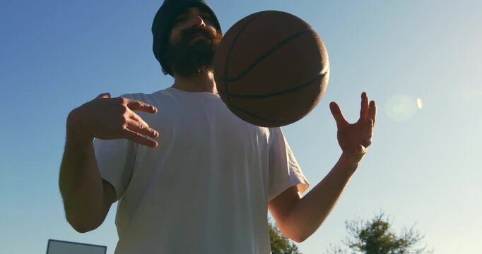 Slow motion  close up of young man playing practice basketball on outdoor court at sunset. Natural light, urban sport lifestyle and freedom concept. - Powered by Adobe