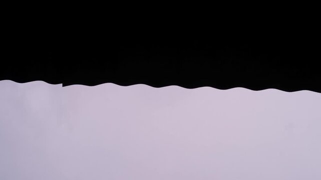 Low-angle footage of rainwater dripping from the edge of a zinc roof. Videography of water droplets during heavy rain in the yard. Relaxing ambience in 4K resolution footage.