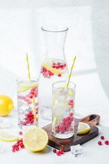 Refreshing drink with lemon slices and red berries served in clear glasses with yellow striped straws
