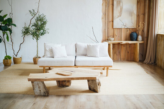 Cozy living room with white couch, wood table, plants, and neutral decor