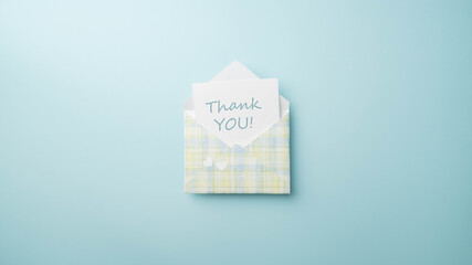 Thank you, message on white note card with blue, white, green and yellow plaid envelope on a matching blue background.