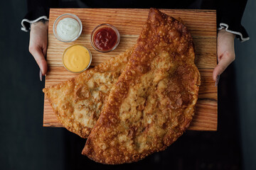 Close-up of freshly made pastel with assorted dipping sauces on wooden board