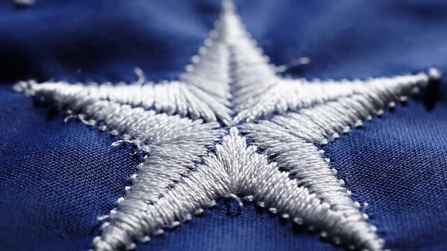 Extreme Close-Up Macro Shot of White Star Embroidery on Blue Fabric Texture