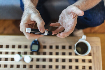 House, hands and man with diabetes machine, testing for glucose levels and chronic disease. Closeup, apartment and person in living room, medical and sugar with insulin, monitor and hypertension.