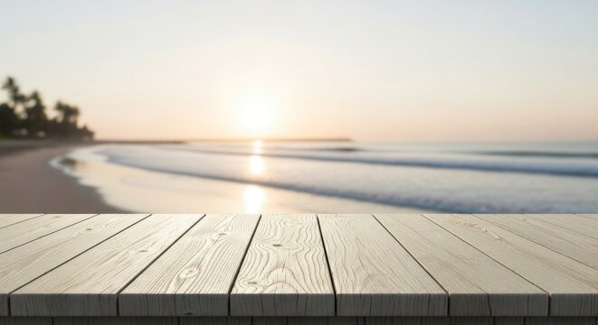 Wooden table in foreground with blurred tropical beach and ocean at sunset.