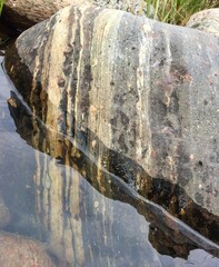 Rock with pattern reflected in the water