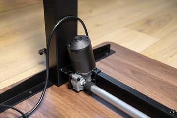 Electric motor and mechanical drive mechanism of an adjustable standing desk, enabling ergonomic height adjustment for a dynamic workspace